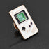 A cute little enamel pin of a white Nintendo Game Boy