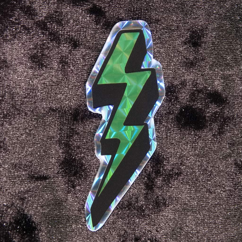 Prismatic or holographic green sticker in neon colors and in the shape of the lightning bolts we used to draw in our schoolbooks back in the 80s and 90s