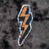 Prismatic or holographic orange sticker in neon colors and in the shape of the lightning bolts we used to draw in our schoolbooks back in the 80s and 90s