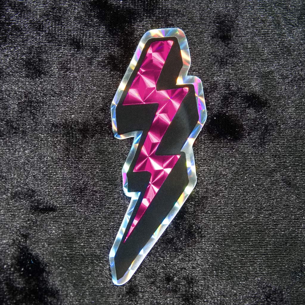 Prismatic or holographic pink sticker in neon colors and in the shape of the lightning bolts we used to draw in our schoolbooks back in the 80s and 90s